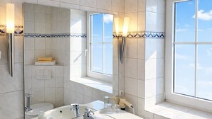 Ein modernes Badezimmer mit einem großen Waschbecken, einem Spiegel und einem Fenster.