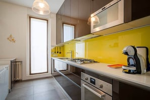 A modern kitchen with a yellow backsplash, stainless steel appliances, and a window providing natural light. - [Glamorous Terrace] Excl. 3bdr at 300mt from Central (Milan)