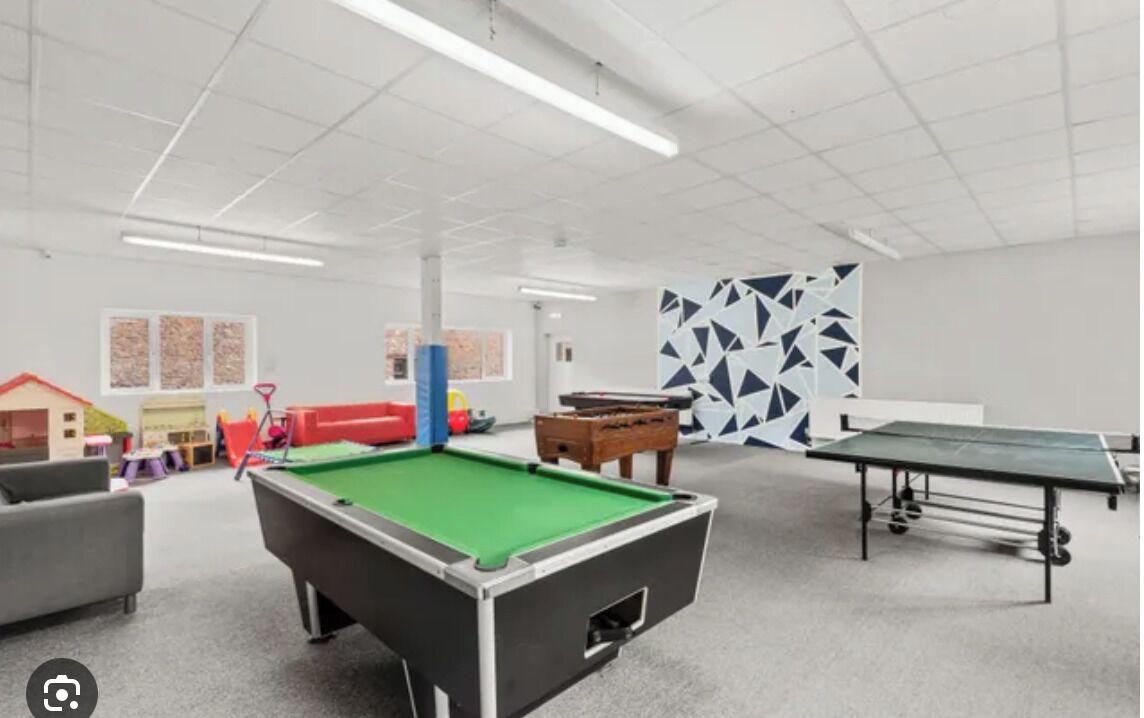 Une salle de loisirs équipée d’une table de billard, d’un baby-foot et d’une table de ping-pong.
