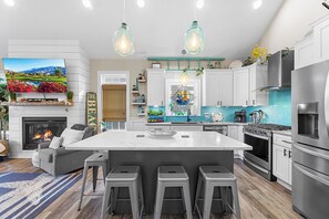 A modern kitchen with a large island, stainless steel appliances, and pendant lighting. - North Bayshore House  Broadkill Beach (Milton)