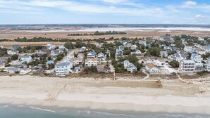 Zona residencial costera con casas, una playa y una masa de agua distante.