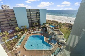 Ein Hotel mit Pool, Meerblick und mehreren Etagen.