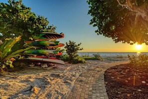 A pathway leading to a beach with kayaks lined up on the sand. - Longboat Key Shore Beach View (Longboat Key)