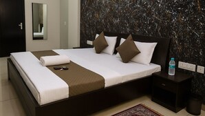 Ein modernes Hotelzimmer mit einem großen Bett, einem Nachttisch, einem Spiegel und einer Marmorwand.