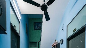 Ein Zimmer mit Treppe, Schreibtisch, Stuhl und Deckenventilator.