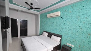 Ein Schlafzimmer mit Bett, Deckenventilator, Klimaanlage und Fernseher.