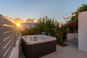 A hot tub on a rooftop terrace with a sunset in the background. - Modern Village House in Paros with Jacuzzi close to the Sea (Paros)