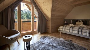 A cozy bedroom with a wooden ceiling, a bed with a plaid blanket, a chair, and a fur rug. - Comfortable Holiday Villa With Mountain Views (Zakopane)