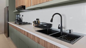A modern kitchen with a built-in gas stove, a black faucet, and a stainless steel sink. - Beachfront Modern Villa with Pool | Azure (Punta Rucia)