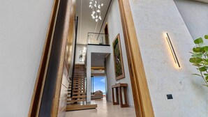 A modern interior with a staircase, wooden accents, and a view to the outside. - Beachfront Modern Villa with Pool | Azure (Punta Rucia)