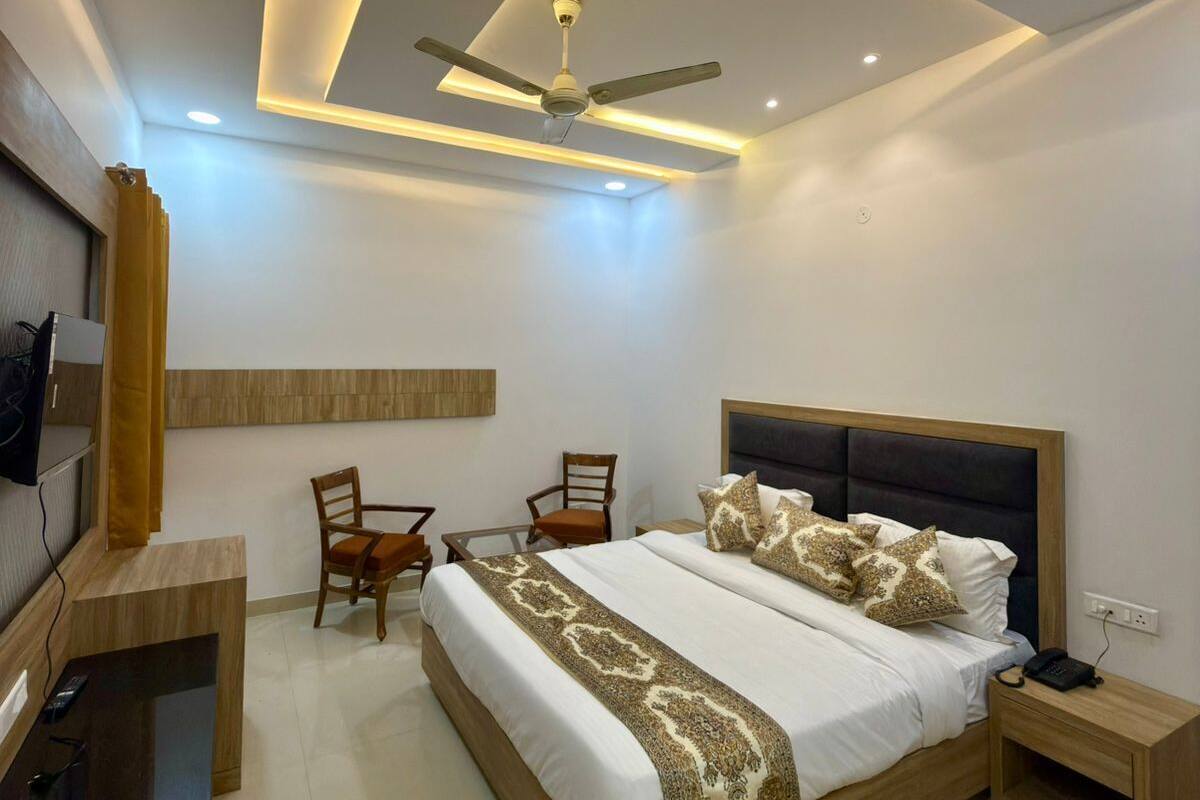 A modern bedroom with a large bed, a ceiling fan, and a desk with a chair.