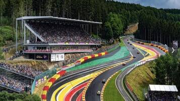 Une piste de course dotée de plusieurs voies et d’une tribune remplie de spectateurs.