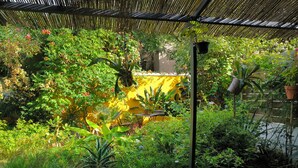 Un jardin luxuriant, avec une variété de plantes et une terrasse en bois.