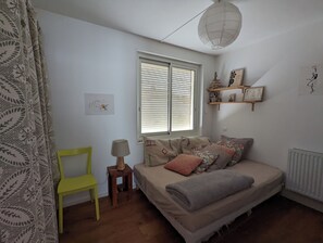 A bedroom with a bed, a chair, a lamp, a window with blinds, and a radiator. - House with a lovely garden that's not visible from the street (Sète)