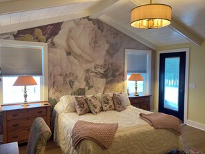 A bedroom with a large bed, two nightstands, a chair, a door, and a window with blinds. - Skaneateles country home just a short walk to downtown  (Skaneateles)