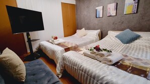 A hotel room with two beds, a TV, and artwork on the wall.