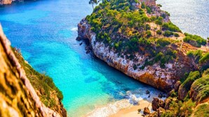 A coastal landscape with a rocky cliff, clear blue sea, and a sandy beach. - Peaceful Apartment Close to the Coast (Conil de la Frontera)