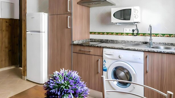A compact kitchen with a built-in microwave, a dishwasher, and a washing machine. - Peaceful Apartment Close to the Coast (Conil de la Frontera)