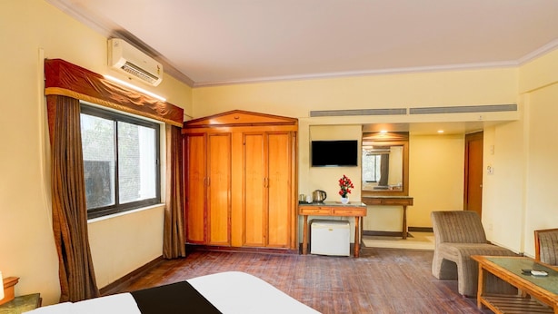 Une chambre d’hôtel équipée d’un lit, d’un bureau, d’une chaise, d’une télévision et d’un appareil de climatisation.