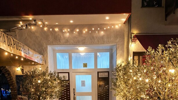 A hotel entrance with a tiled pathway, potted plants, and string lights. - Corner view Residence | Panorama balcony (Koblenz)