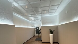 A hallway with a wooden floor, white walls, and a ceiling with recessed lighting. - Corner view Residence | Panorama balcony (Koblenz)