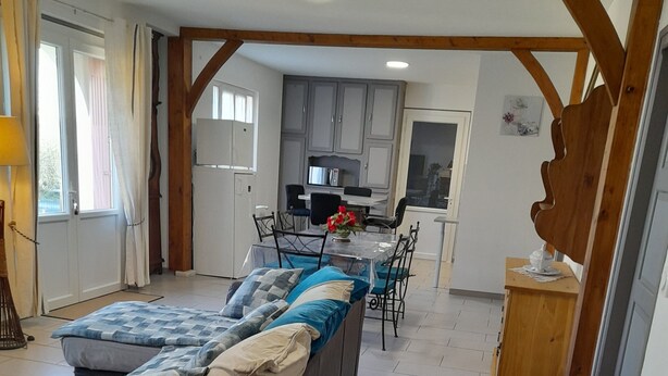 A spacious living area with a sofa, a dining table, and a kitchen in the background. - COUNTRY HOUSE in FONROQUE 2km from BASTIDE D'EYMET (Fonroque)