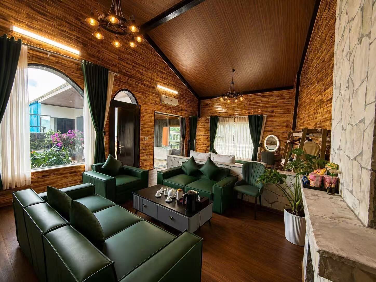 Una sala de estar moderna con sofás verdes, una mesa de centro y una chimenea.