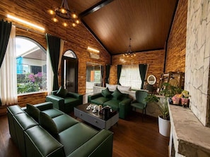 A modern living room with green sofas, a coffee table, and a fireplace. - Cloud Chaser Hotel (Sa Pa)