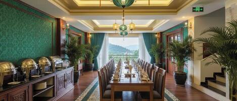 A formal dining room with a long table, chairs, and a buffet on one side.