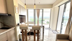 Un salon moderne comprenant un canapé, une table à manger avec des chaises et un coin cuisine avec une cuisinière.