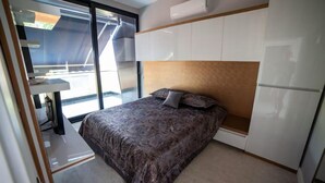 A modern bedroom with a large bed, built-in wardrobe, and a sliding glass door leading to a balcony. - Private Wellness Residence with Heated Pool (Antalya)