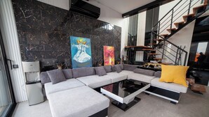 A modern living room with a sectional sofa, a coffee table, and artwork on the walls. - Private Wellness Residence with Heated Pool (Antalya)
