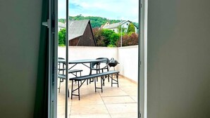 A bedroom with a bed, a sliding glass door leading to an outdoor patio with a table and chairs. - Odw homes - Large apartment with four bedrooms (Weinheim)