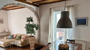 A cozy living room with a glass dining table, a comfortable sofa, a potted plant, and a view through a window. - Odw Homes – Charming Home in Gorxheimertal (Gorxheimertal)