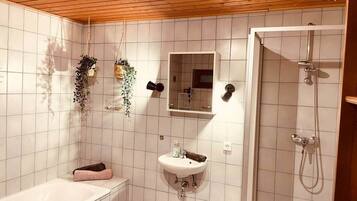 Ein Badezimmer mit Waschbecken, Spiegel und Dusche.