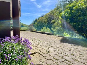 A paved pathway leading to a building with a view of a green hill and trees. - Odw homes - Flat in country home with terrace (Gorxheimertal)