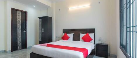 A modern bedroom with a large bed, a wardrobe, a nightstand, and a window with bars.