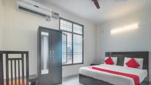 A hotel room with a bed, a wardrobe, and a window. - Hotel O The Grand Venice Mall (Noida)