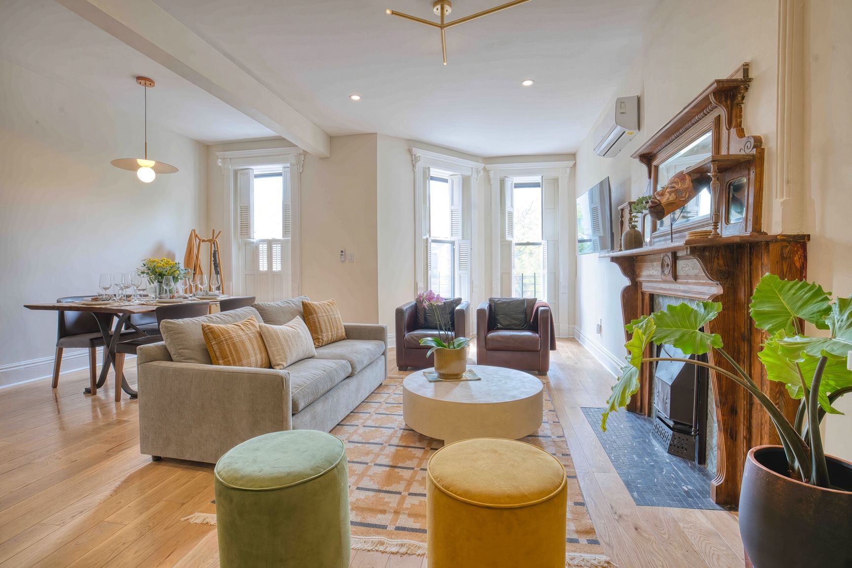 Un salon spacieux comprenant un canapé, des fauteuils, une table basse et une cheminée.