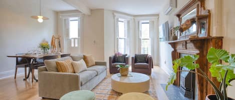 Un salón espacioso con sofá, sillones, una mesa de centro y chimenea.