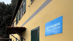 A yellow building with a blue sign reading "AFFITTACAMERE Casa Lucia". - Casa lucia (La Spezia)