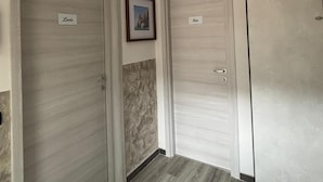A hallway with three doors labeled "Lucia," "Sus," and "Sofia." - Casa lucia (La Spezia)