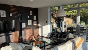 Una sala de estar moderna con un sofá blanco, un televisor de pantalla plana y una mesa de centro.