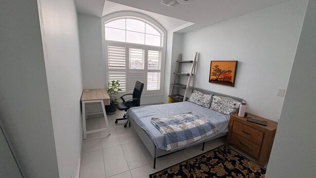 A bedroom with a bed, a desk, a chair, a window, and a painting on the wall. - One bedroom and one washroom (Oakville)