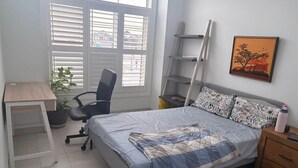 A bedroom with a bed, a desk, a chair, a ladder, a plant, and a painting on the wall. - One bedroom and one washroom (Oakville)