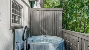 A hot tub on a wooden deck with a window and a hose. - Cozy Escape • Hot Tub • Overlooks Helen Main Street • Sleeps 9 (Helen)