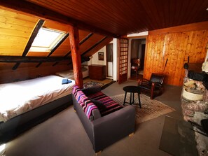 Ein Schlafzimmer im Loft-Stil mit einem Bett, einer Couch und einem Essbereich.