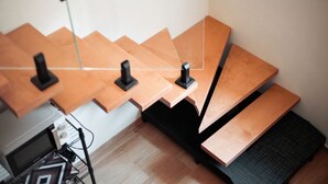 Ein modernes Interieur mit gestuften Holztischen und einem schwarzen Metallständer.