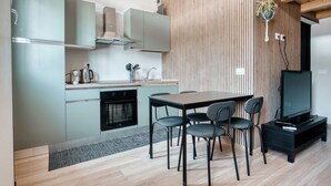 Eine moderne Küche mit Essbereich, Holzvertäfelung und einem Fernseher.