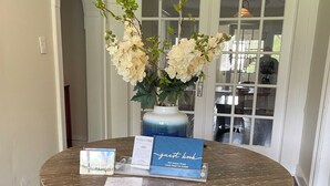 A round table with a blue guest book, a vase with white flowers, and a welcome sign. - Closest Stay to Corry House and Durhamtown Off Road Resort!! Historic House (Union Point)